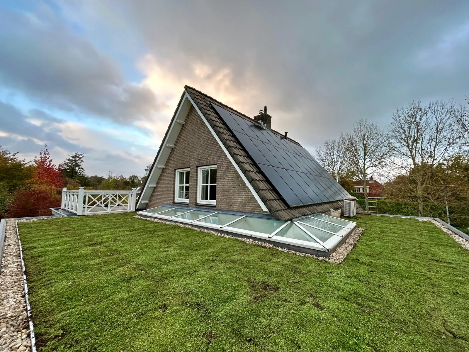 Groen dak op een plat dak naast een woning met zonnepanelen